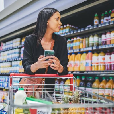 Scott E. Burgess Immersion program - client in grocery store receiving virtual support on meal planning, nutrition, and BALANCED tools integration.