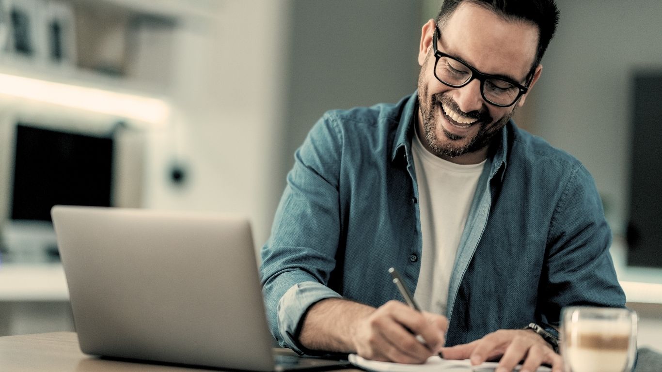 Client writing notes during Virtual RTT session with Scott E. Burgess, happy to experience breakthroughs and personal transformation from home.