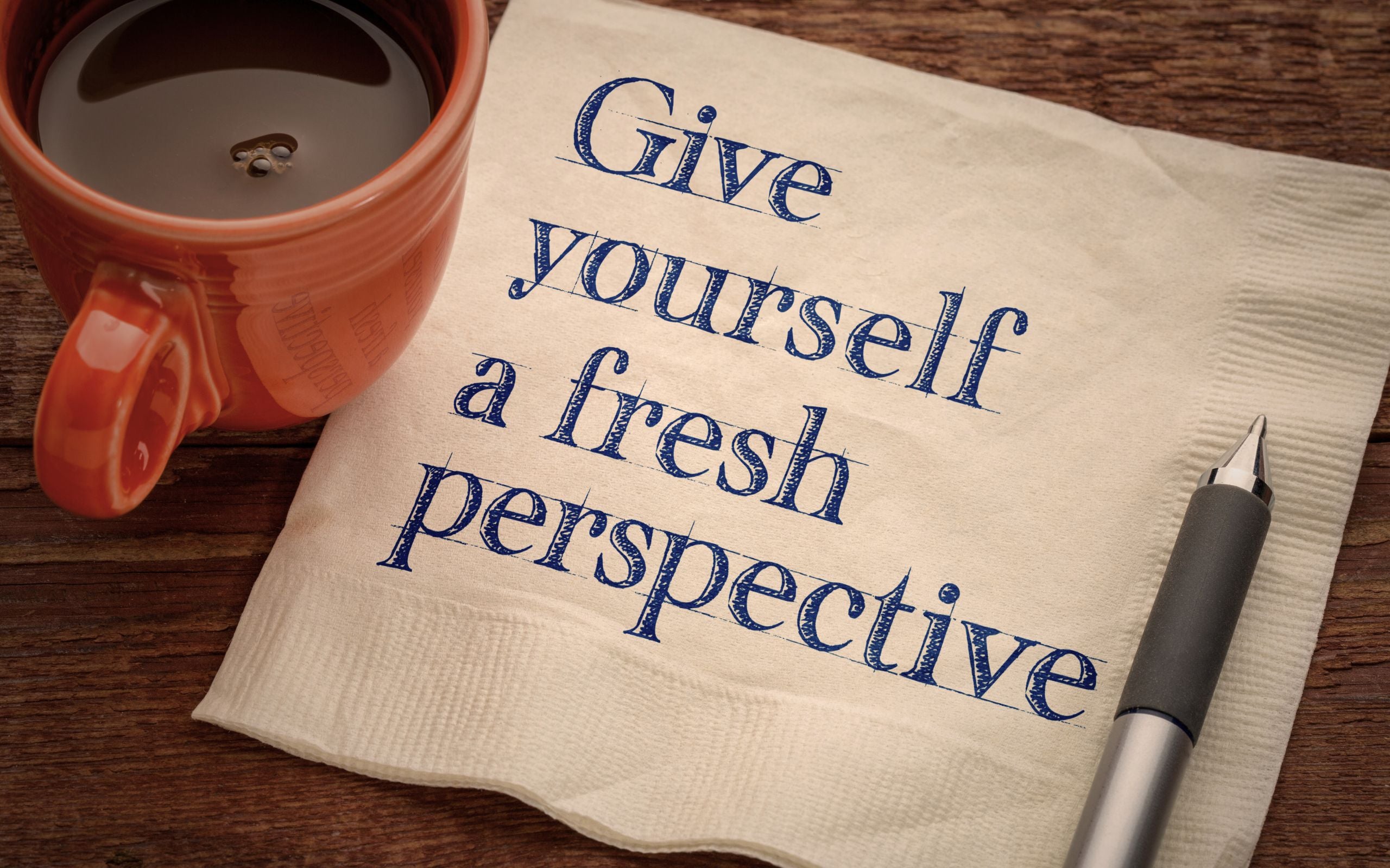 Coffee cup with napkin message give yourself a fresh perspective, symbolizing reflection and transformation in RTT sessions with Scott E. Burgess.