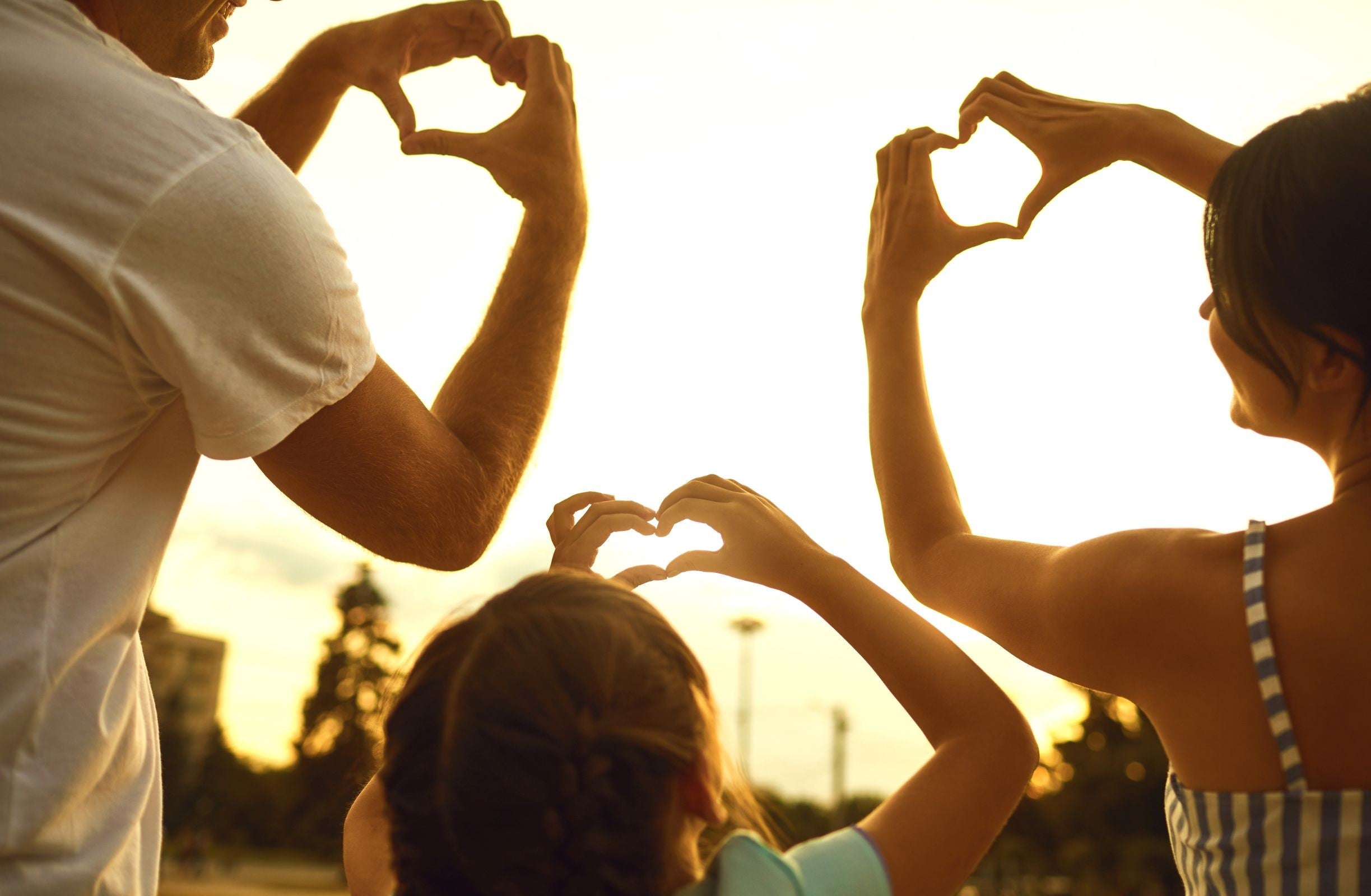 Family showing love sign with hands after RTT session with Scott E. Burgess, celebrating healing, connection, and bringing family closer together.